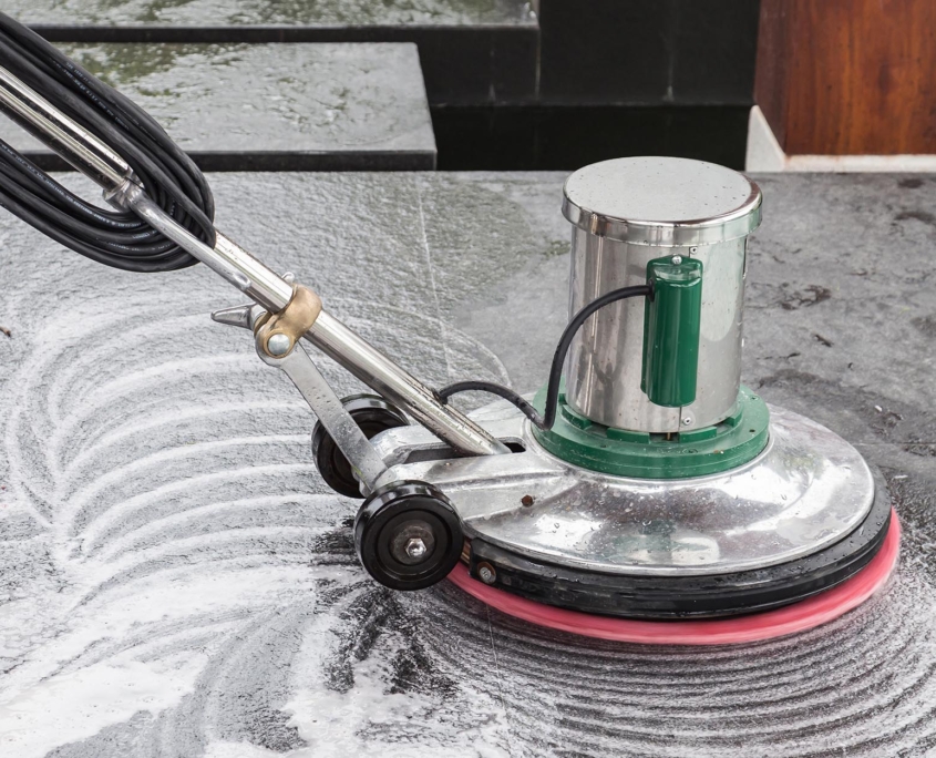 Side view of a hard floor being cleaned by large machine