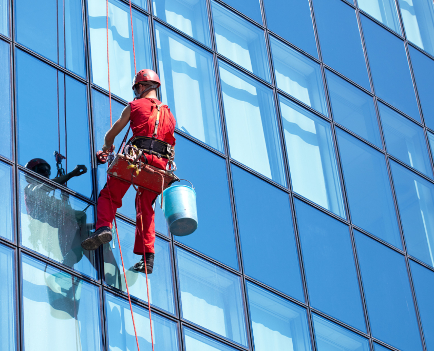 Side view of a professional cleaning windows on a high rise building