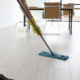 Side view of a cleaner mopping a hard floor in office break room