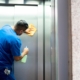 Janitor disinfecting office building elevator