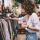 Side view of woman with curly hair looking at clothes at retail store